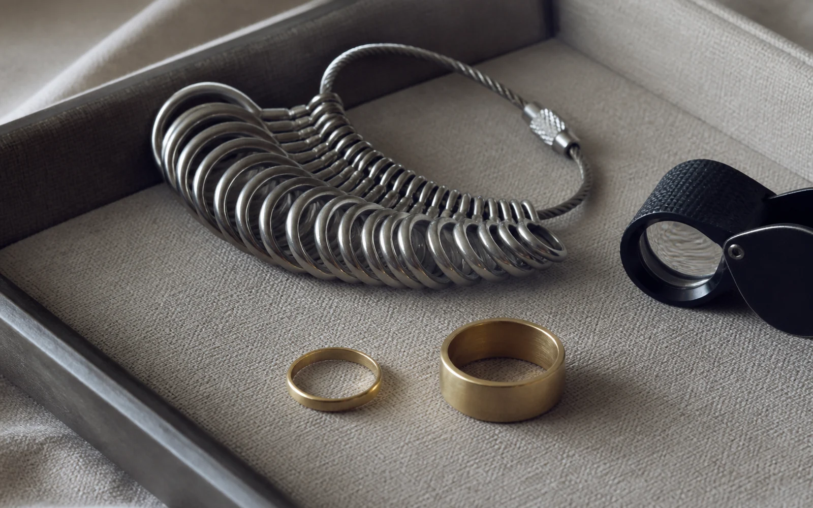 Narrow ring and wide band beside a ring sizing set for a fit comparison
